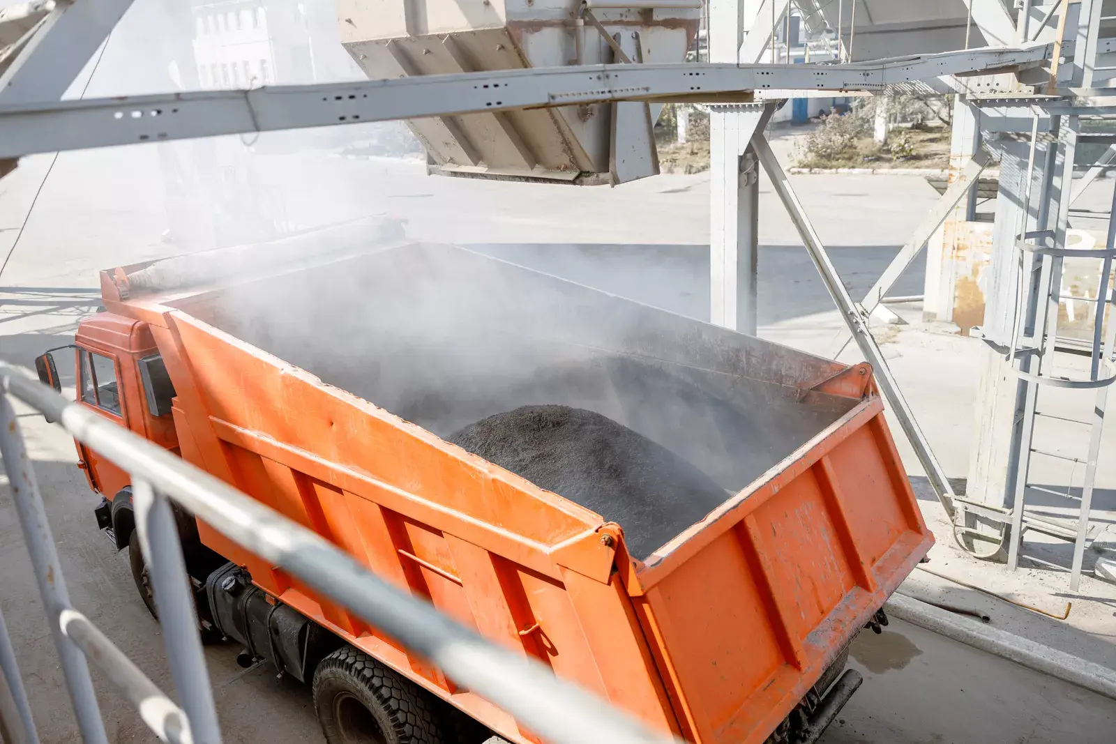 Industrial bulk loading operation showing dust control and bulk loading systems managing airborne dust during material transfer.